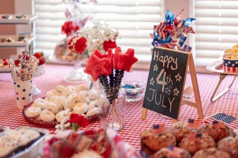 table decorated with red, white and blue food and decorations for the 4th of July.