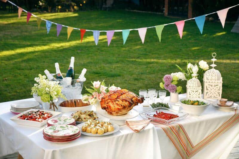 table in the garden decked out with food - Summer Party Ideas