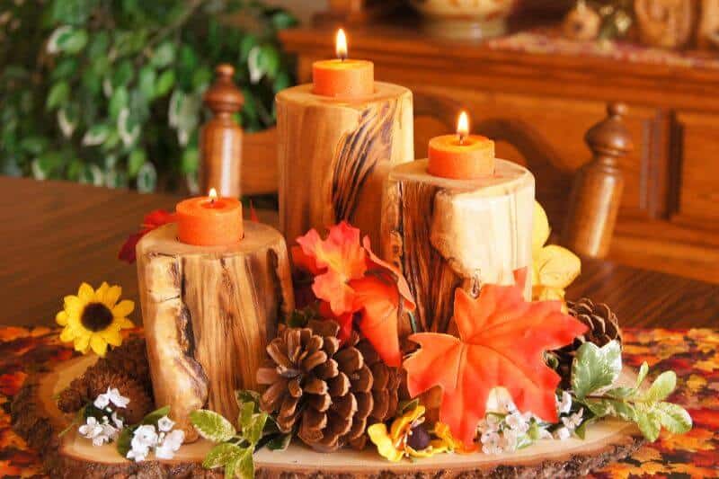 handmade fall centerpiece with leaves, pine cones and candles.