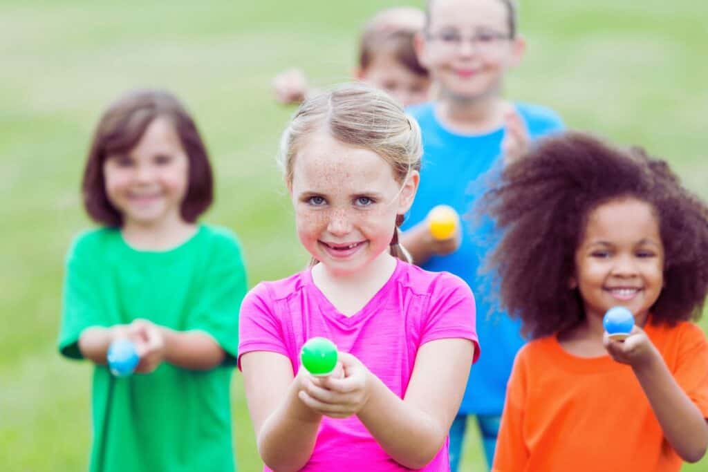 Multi-racial kids participating in an Easter egg and spoon race outdoors