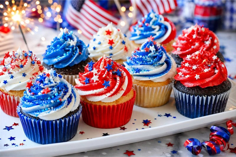 A platter of cupcakes with red, white, and blue frosting decorated for a 4th of July celebration.