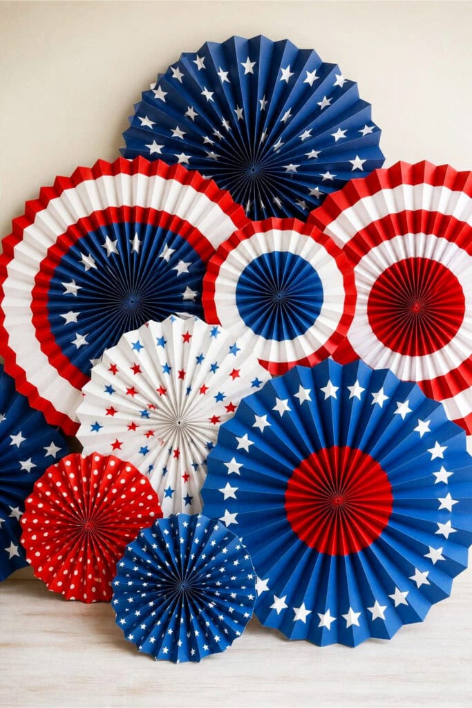 A display of red, white, and blue accordion paper fans with star and stripe patterns arranged together.