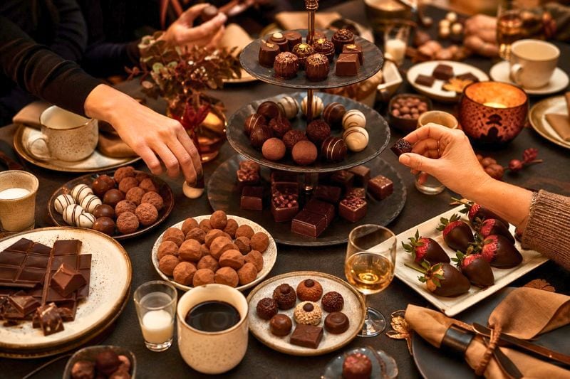 Guests sample assorted chocolates at an elegant tasting party.